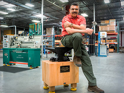 Shiraz Balolia poses next to an anvil for which he made the stand for