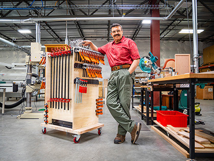 Shiraz poses next to a clamp rack that he made